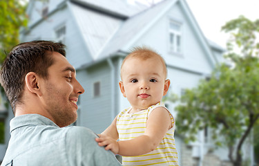 Image showing father with little baby daughter over house