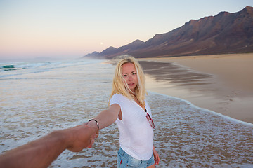 Image showing Romantic couple holding hands on beach.