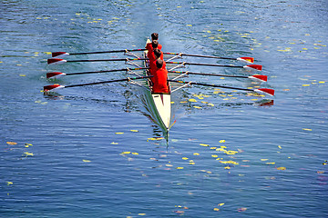 Image showing Men's quadruple rowing team on blue water