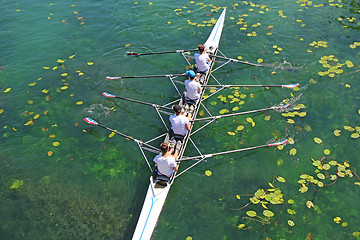 Image showing Men's quadruple rowing team on green water