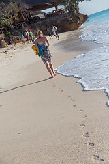 Image showing Woman running on the beach in sunset.