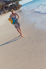 Image showing Woman running on the beach in sunset.