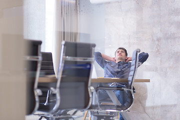 Image showing young businessman relaxing at the desk