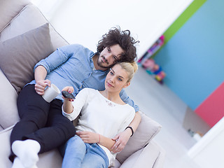 Image showing Young couple on the sofa watching television