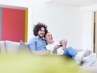 Image showing Young couple on the sofa watching television