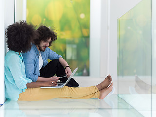 Image showing multiethnic couple using a laptop on the floor