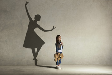 Image showing Baby girl dreaming a dancing ballet on the stage. Childhood concept.