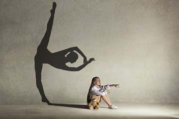 Image showing Baby girl dreaming a dancing ballet on the stage. Childhood concept.