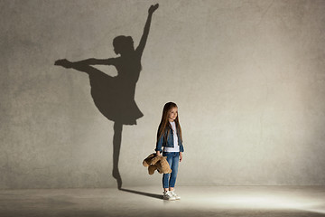 Image showing Baby girl dreaming a dancing ballet on the stage. Childhood concept.