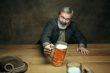 Image showing Smiling bearded male drinking beer in pub