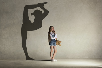 Image showing Baby girl dreaming about gymnast profession. Childhood concept.