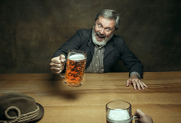 Image showing Smiling bearded male drinking beer in pub