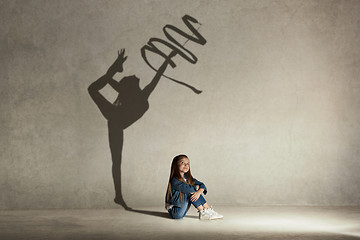 Image showing Baby girl dreaming about gymnast profession. Childhood concept.