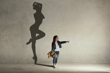 Image showing Baby girl dreaming a dancing ballet on the stage. Childhood concept.