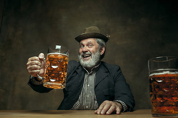 Image showing Smiling bearded male drinking beer in pub