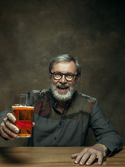 Image showing Smiling bearded male drinking beer in pub