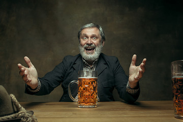 Image showing Smiling bearded male drinking beer in pub