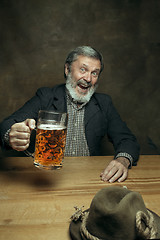 Image showing Smiling bearded male drinking beer in pub