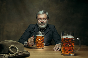 Image showing Smiling bearded male drinking beer in pub