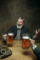 Image showing Smiling bearded male drinking beer in pub