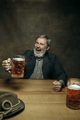 Image showing Smiling bearded male drinking beer in pub