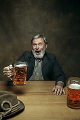 Image showing Smiling bearded male drinking beer in pub