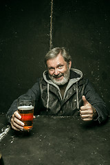 Image showing Smiling bearded male drinking beer in pub