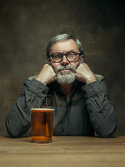 Image showing Sad bearded male drinking beer in pub