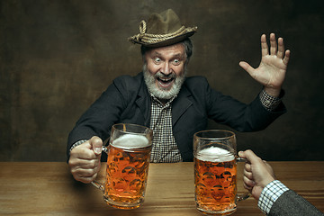 Image showing Smiling bearded male drinking beer in pub