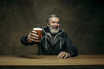 Image showing Smiling bearded male drinking beer in pub