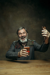 Image showing Smiling bearded male drinking beer in pub