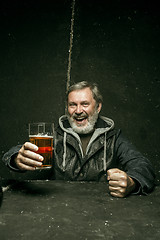 Image showing Smiling bearded male drinking beer in pub