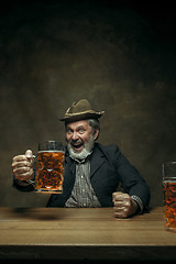 Image showing Smiling bearded male drinking beer in pub
