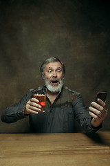 Image showing Smiling bearded male drinking beer in pub