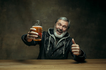 Image showing Smiling bearded male drinking beer in pub