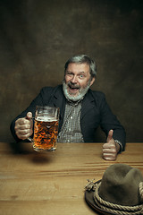 Image showing Smiling bearded male drinking beer in pub