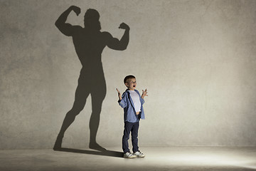 Image showing The little boy dreaming about athletic bodybuilder figure with muscles