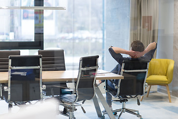 Image showing young businessman relaxing at the desk