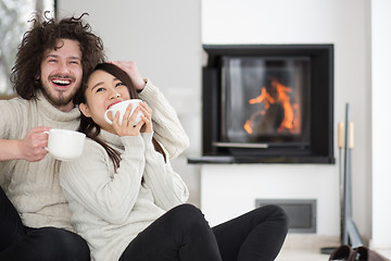 Image showing happy multiethnic couple  in front of fireplace