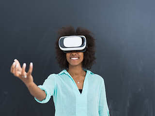 Image showing black girl using VR headset isolated on gray background