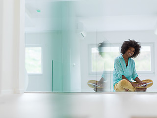 Image showing black women using tablet computer on the floor at home