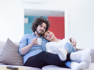 Image showing Young couple on the sofa watching television