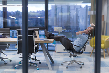 Image showing young businessman relaxing at the desk