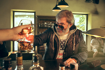 Image showing The senior bearded male drinking beer in pub