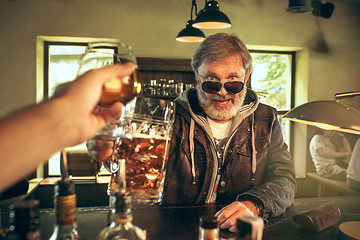 Image showing The senior bearded male drinking beer in pub