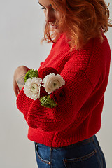 Image showing A girl with a tattoo on her hands holding a bouquet of flowers on a gray.