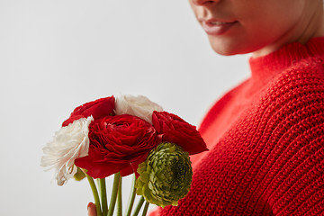 Image showing Woman in a red sweatshirt with flowers Buttercup on a white background.