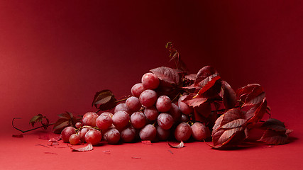 Image showing ripe fresh red grapes on a red background