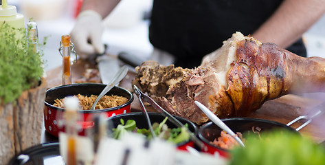 Image showing Cheff serving traditional meat dish on street stall on street food festival, Ljubljana, Slovenia.