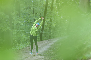 Image showing Sporty woman working out in forest.